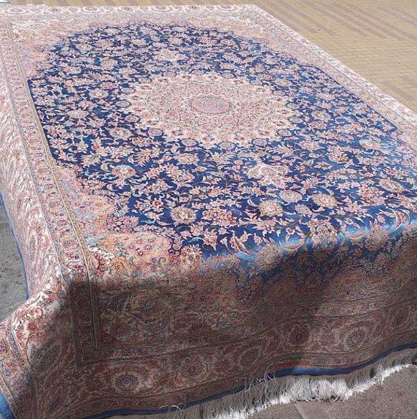 A large 225x150 cm navy blue silk-touch rug with a traditional ivory floral pattern in a grand living room setting.