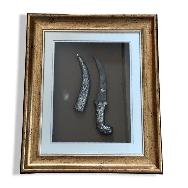 Full setting presentation of the premium framed Middle Eastern heritage dagger styled on an upscale corporate majlis wall serving as an elite milestone token or VIP hospitality giveaway decoration in Dubai.