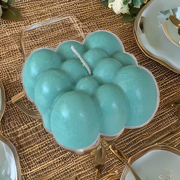 A professional product presentation of the exclusive teal blue bubble candle from a premier UAE gift shop.
