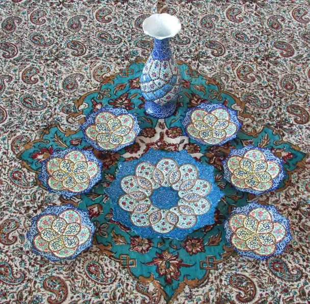 Full overhead exhibition view of a luxury hand-painted Minakari copper Haft-Sin table setting featuring a central display plate, six small bowls, and a decorative vase in traditional blue patterns.um Design Showcase