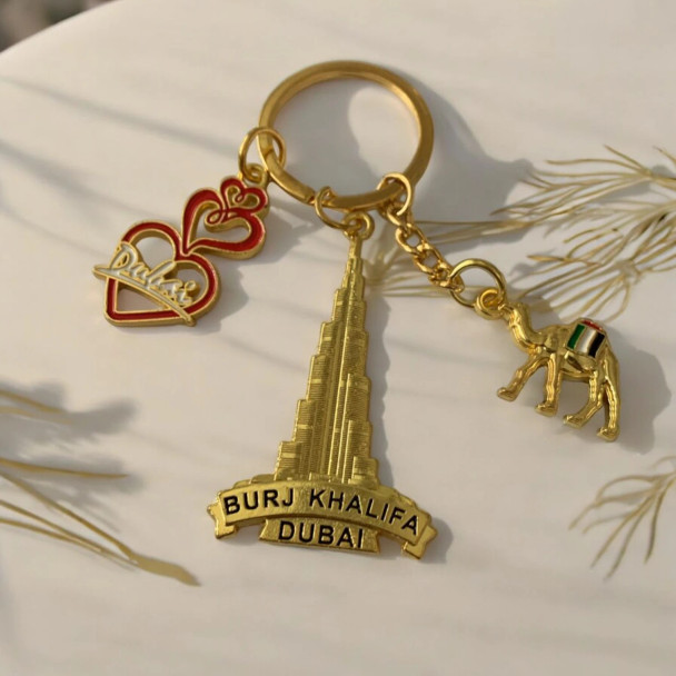 A high-quality, gold-toned Dubai souvenir keychain set against a neutral background, highlighting its intricate design and craftsmanship.