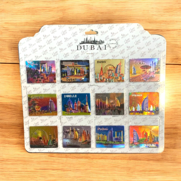 Complete presentation of the premium set of 12 printed foil Dubai souvenir magnets, showcasing a collection of gleaming, vibrant city landmark designs arranged elegantly.