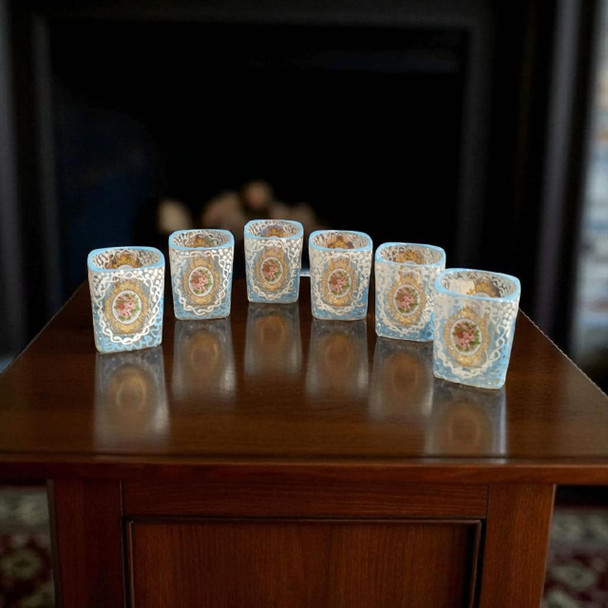A set of six elegant, hand-painted shot glasses featuring ornate gold and blue decorative frames, perfect for sophisticated entertaining.