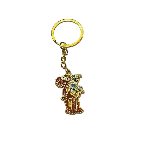 A playful, chibi-style enamel camel keychain in gold-tone metal with a colorful traditional saddle.