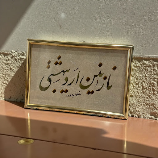 A 15.5 x 10.5 cm gold frame featuring the hand-written Persian phrase 'نازنين ارديبهشتي' (Nazanin-e Ordibeheshti) in elegant black Nastaliq script.