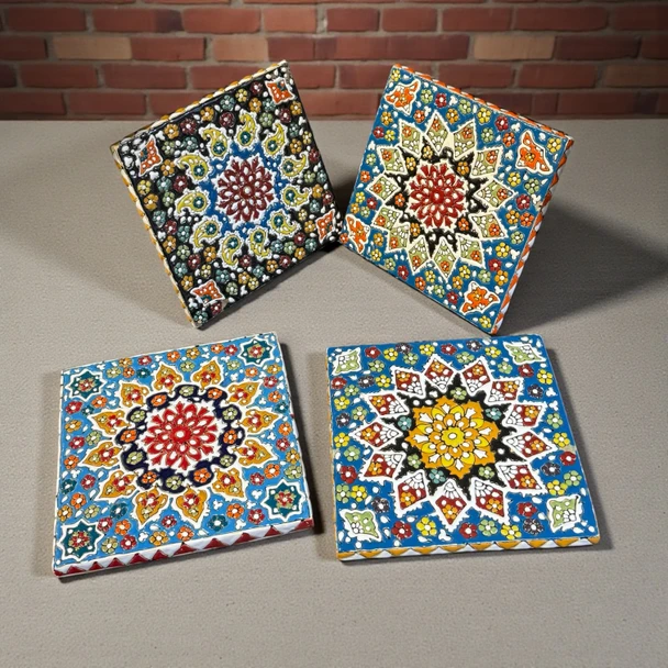Four Square Hand-Painted Clay Tiles With Embossed Colorful Patterns And Glossy Glazed Finishes.