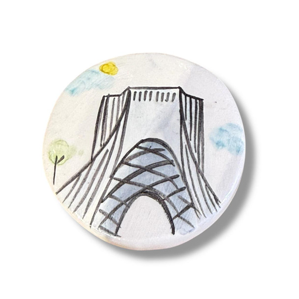 A 5.5 cm circular ceramic fridge magnet featuring a hand-painted illustration of the Azadi Tower in Tehran.