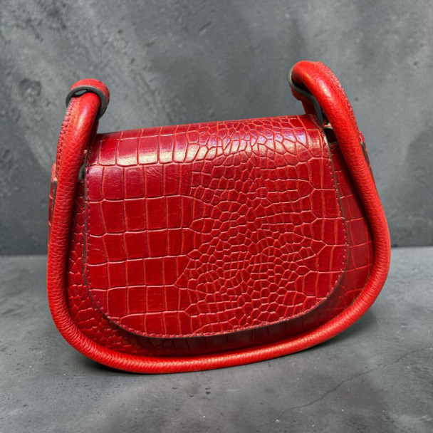 Elegant boutique display presentation of the premium red natural leather handbag with straps, serving as an exceptional high-fashion statement piece or elite designer gift.