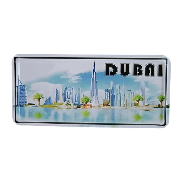 A rectangular printed metal magnet featuring a wide-angle view of Dubai’s famous landmarks and palm trees.