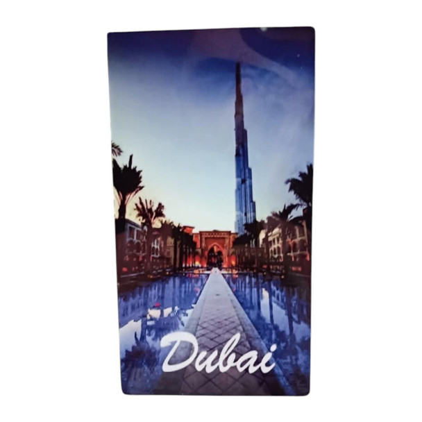 A 14x8 cm vertical aluminum magnet showing the Burj Khalifa tower reflected in a water path, framed by palm trees, with the text "Dubai" at the bottom.