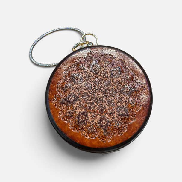 An exclusive Craftihouse circular leather clutch showcasing traditional tooling and fine craftsmanship.