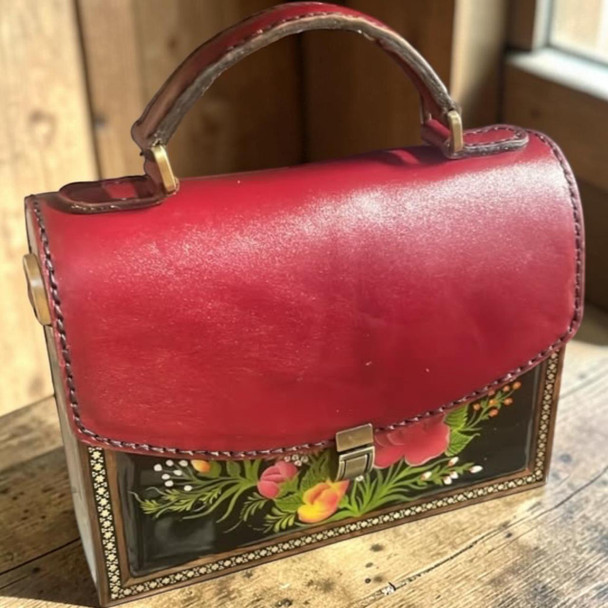 A professional product presentation of the 21x16x7.5 cm handcrafted red leather and black wooden gift handbag against a neutral background.