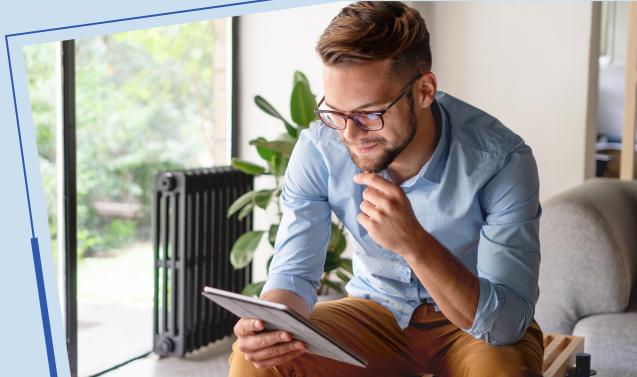 man sitting on a couch reading his tablet