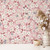 A gorgeously delicate and ditsy floral wallpaper with blossom petals set against a pink background. Great for a bedroom or living room feature wall.