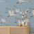 A beautifully illustrated wallpaper with swans in flight set against a blue background.