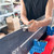 Workshop demonstration showing hands tuning and sharpening a ski or snowboard edge using the XCMAN CNC tool