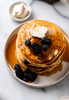 Pancakes topped with butter, fruit and maple syrup