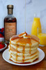 front label of the brown butter flavor maple syrup 250 ml bottle with a pancake stack drizzled with butter and orange juice