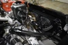 Installed JBtuned B-Series radiator hose tuck kit showing black nylon-braided -16AN coolant hose routing between the engine and aluminum radiator.