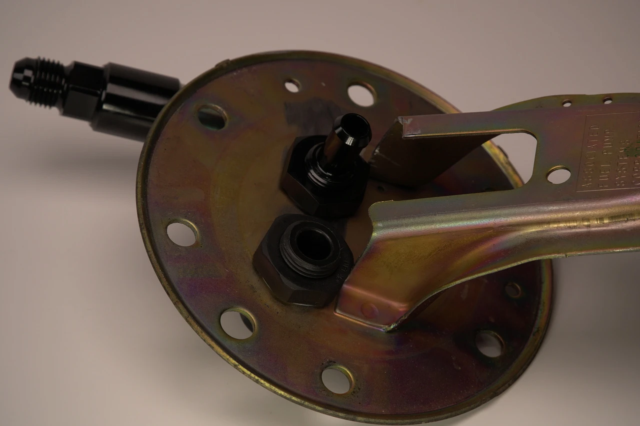Bottom view of JBtuned Civic Integra OEM fuel pump hanger upgrade showing the external AN fuel connections.