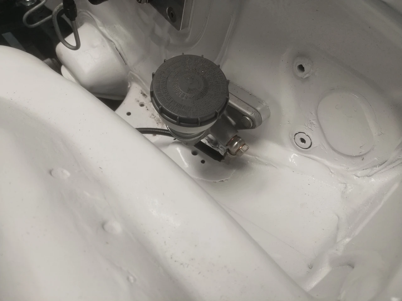 Close-up of JBtuned J-swap clutch line connected to the S2000 clutch master cylinder with stainless-steel connection hardware.