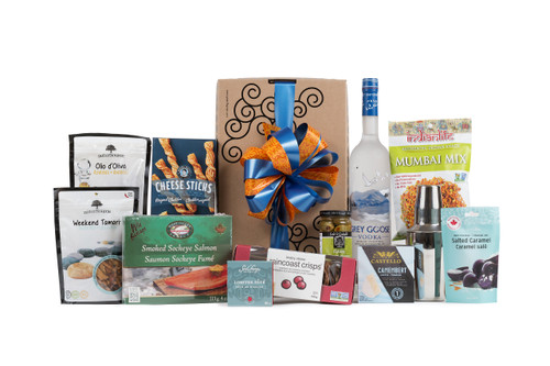 Gourmet gift box featuring Grey Goose vodka, a martini shaker, and snacks (crackers, cheese, pate, etc.).