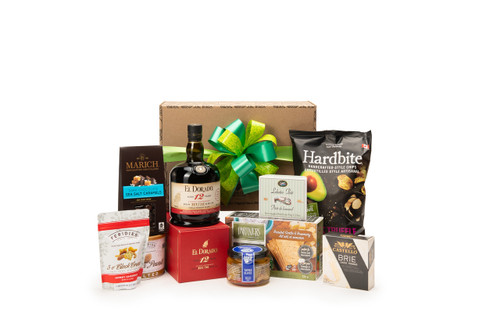 Gourmet rum wine gift box featuring El Dorado 12 Year Old Finest Demerara Rum paired with sweet and savoury snacks (chocolate, crackers, nuts, etc.), packaged in signature Green & Green gift box with ribbon and bow.