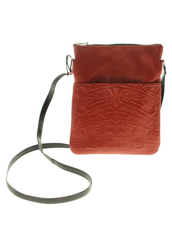 Red leather over-the-shoulder bag, embossed with West Coast First Nations bear design.