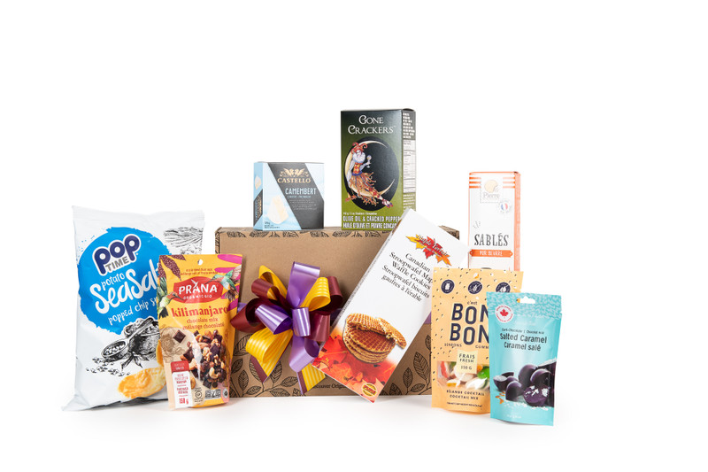 Gourmet gift basket featuring sweet and savoury snacks (chocolate, cookies, crackers, nuts, etc.) packaged in signature Green & Green gift box with ribbon and bow.