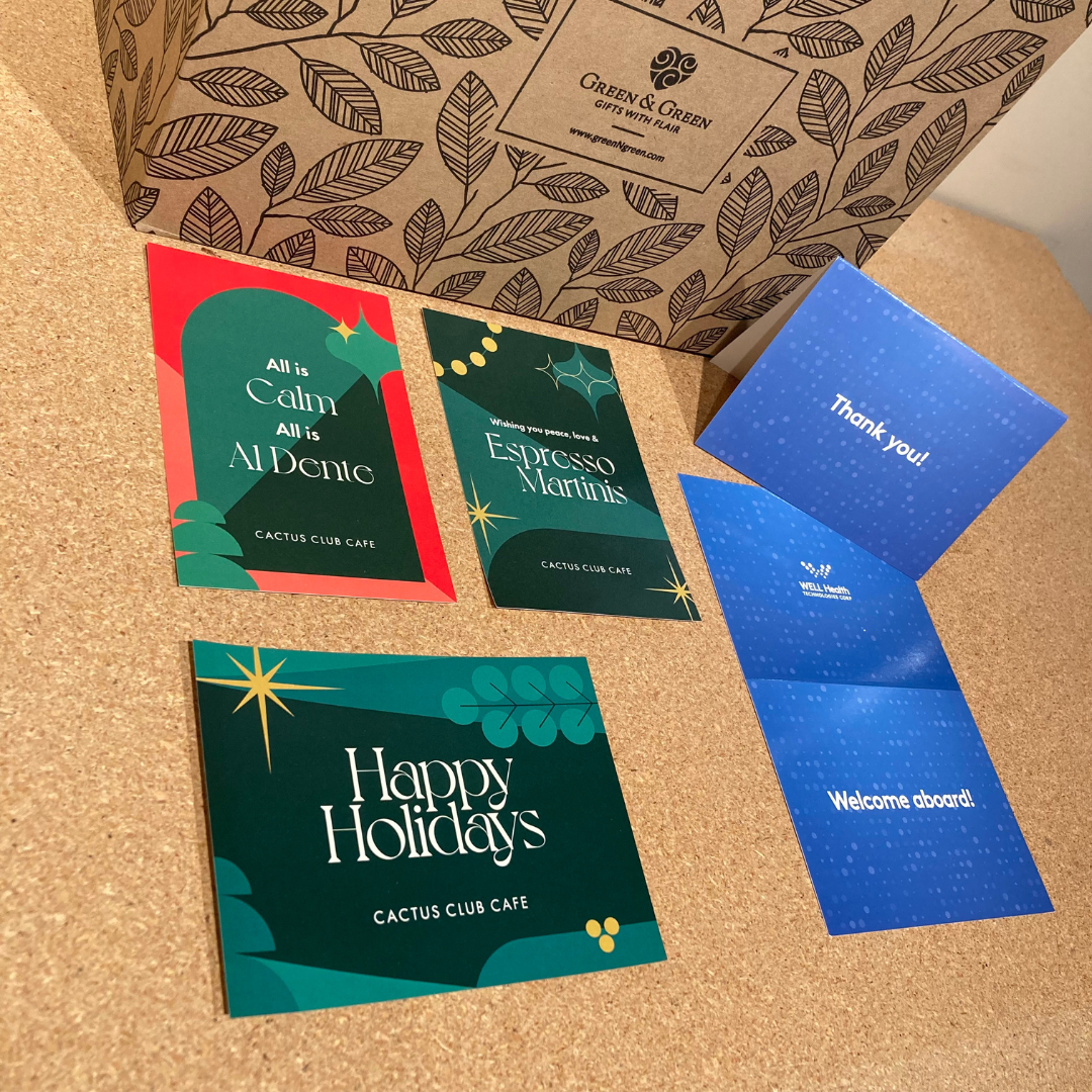 A gift box with branded stickers and cards with logos such as Cactus Club Cafe Restaurant and WELL Health Technologies Corp.