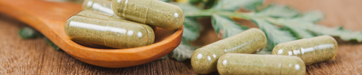 Filled capsules resting on a wooden spoon