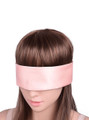 Pink satin ribbon tied as a blindfold over a model's eyes