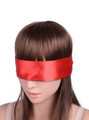 Red satin ribbon blindfold tied across a model’s eyes