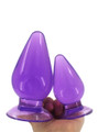 Two purple TPE teardrop plugs in different sizes displayed in a hand for comparison.