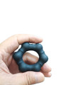 Black silicone cock ring being held in a hand.