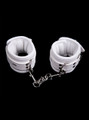 white soft padded leather wrist and ankle cuffs connected by a metal chain.