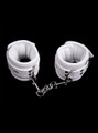 white soft padded leather wrist and ankle cuffs connected by a metal chain.