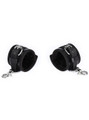 Set of plush-lined black leather handcuffs laid open, showing interior padding
