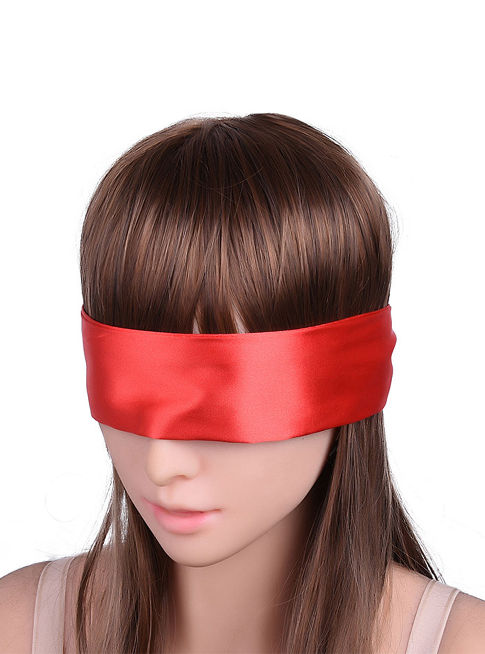 Red satin ribbon blindfold tied across a model’s eyes