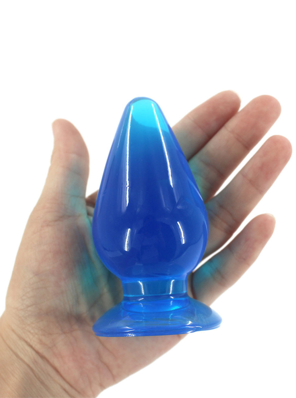 Blue oversized TPE plug held in a hand to demonstrate scale and thickness.