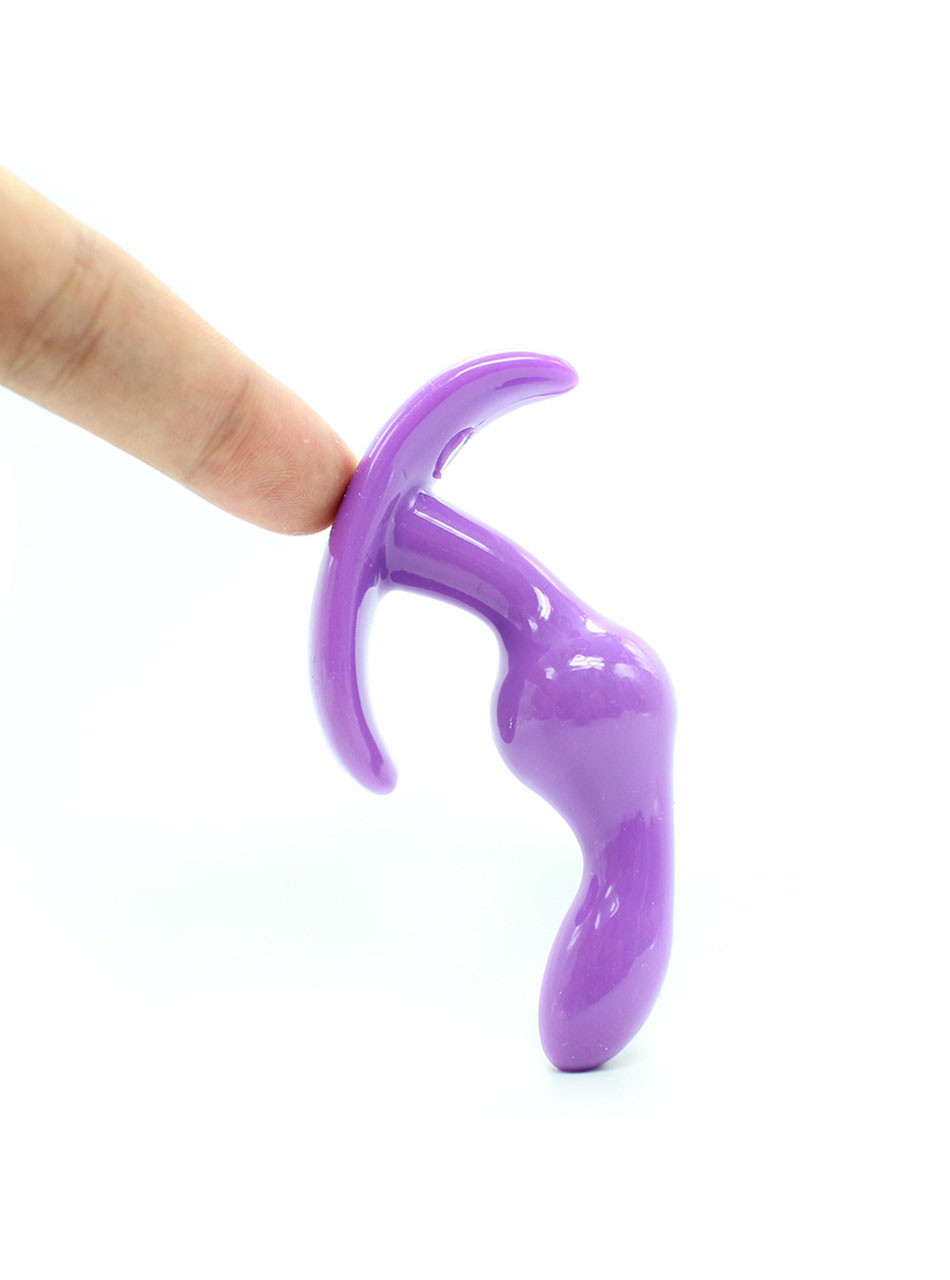 Flexible purple silicone anal plug bending under pressure
