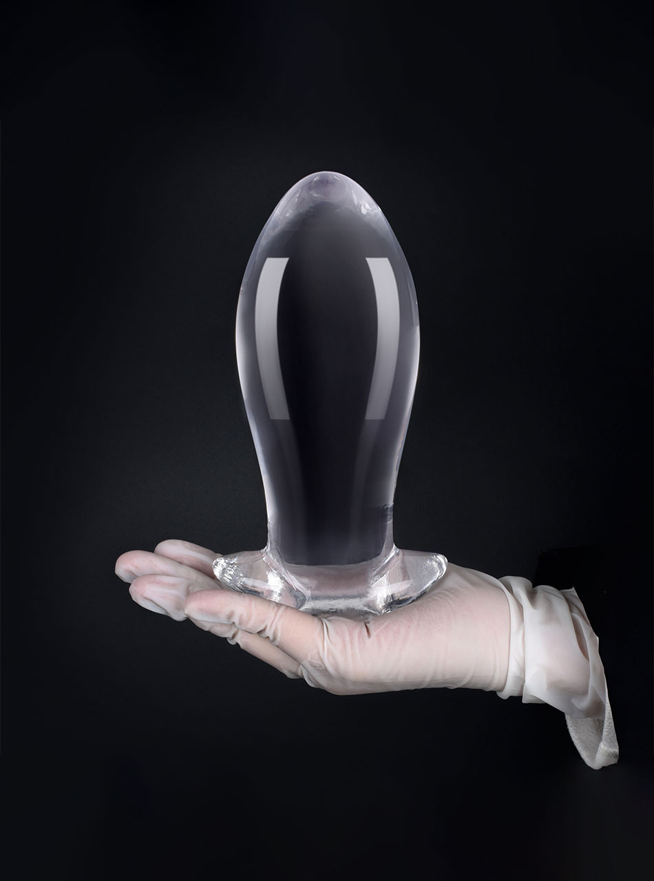 XL clear TPE anal dragon egg butt plug held upright in a gloved hand