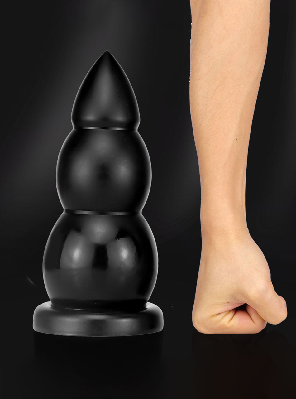 Oversized black triple bulb butt plug shown beside a forearm for scale, measuring 24.3 cm (9.56 in) long
