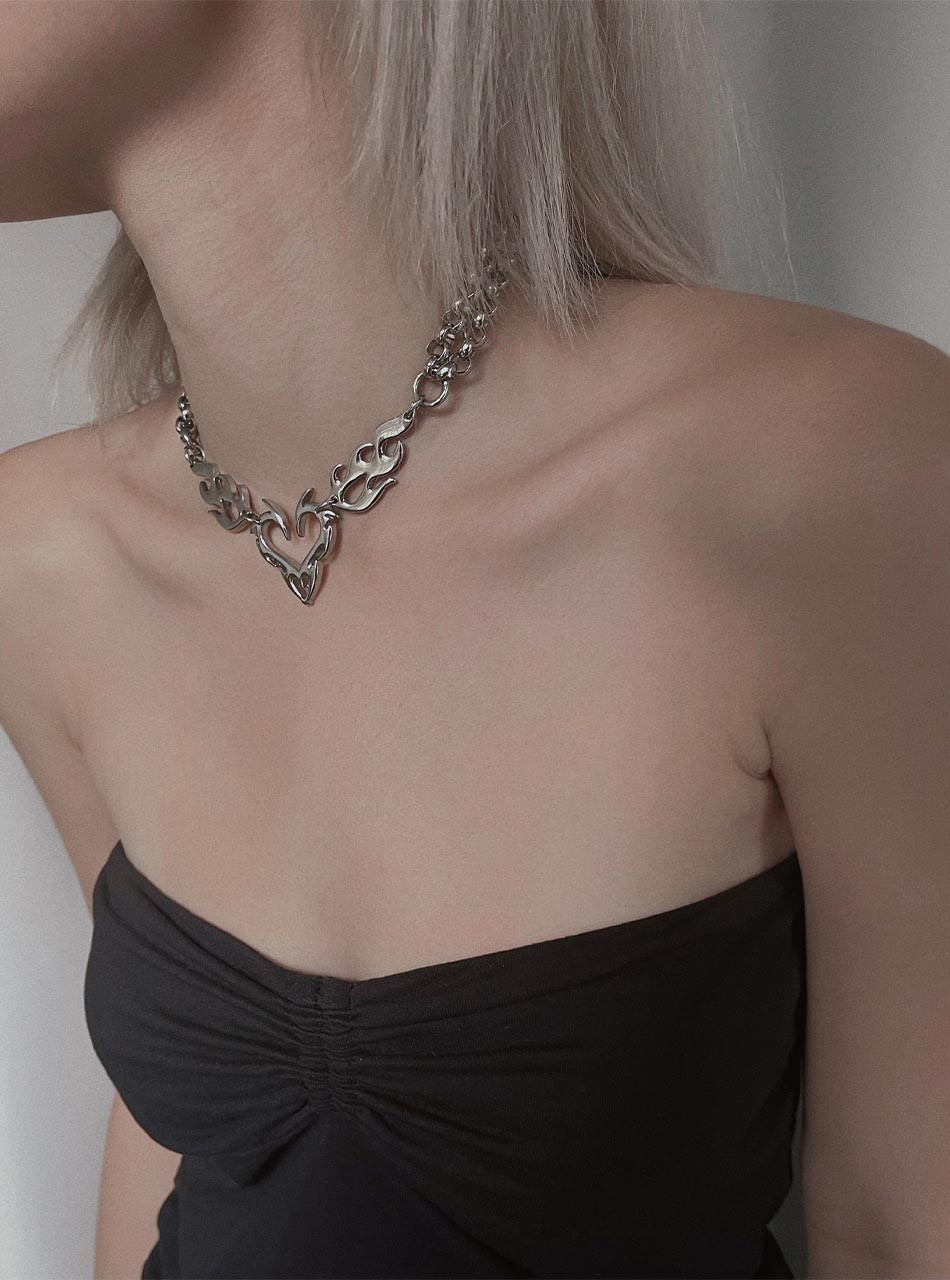 Silver flame heart necklace worn at the collarbone