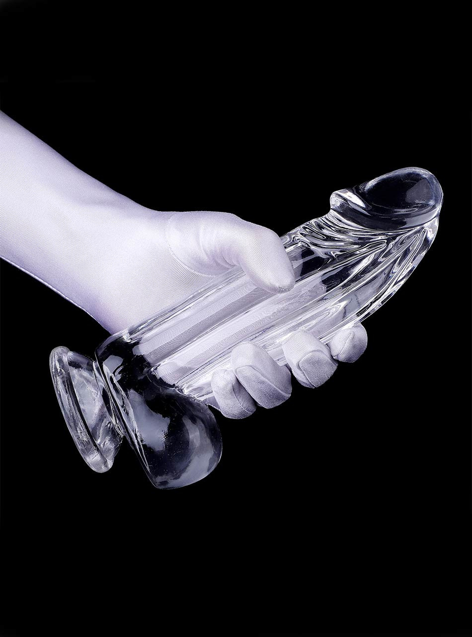 Clear realistic dildo with balls and suction cup held in hand