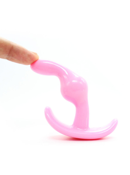 Flexible pink silicone anal plug bending under pressure