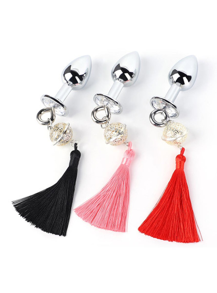 Three metal butt plugs with black, pink, and red tassels and decorative bells on white background