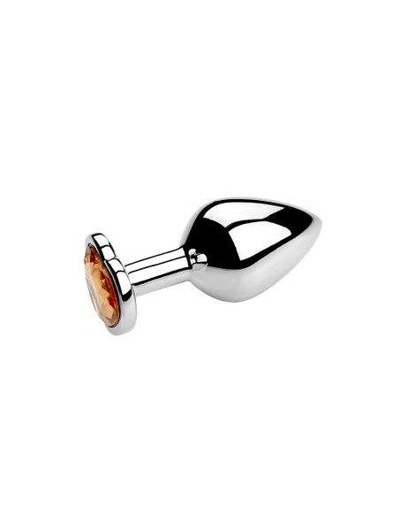 Yellow heart jewel metal butt plug on a reflective surface, ideal for enhancing anal play.