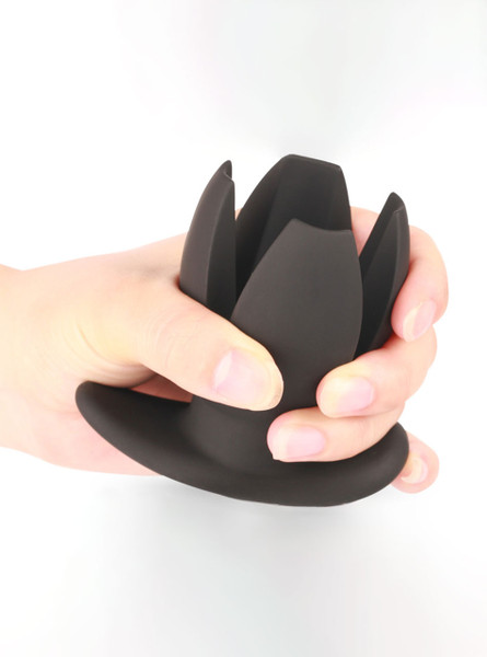 Hand holding the Expandable Silicone Anal Plug with petals partially opened, demonstrating flexibility.