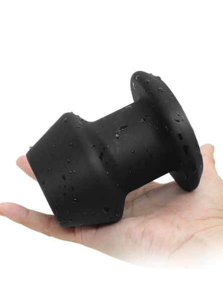 Silicone Hollow Anal Gaper Plug displayed in a hand, highlighting its smooth surface and bold size.